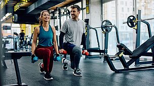 Frau und Mann beim Krafttraining im Fitnessbereich eines Hotels – Bewegung als Baustein eines Longevity-Konzepts