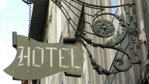 Eine Hauswand, wo ein Schild dranhängt auf dem "Hotel" draufsteht