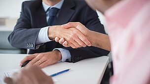 Zwei Personen geben sich die Hand 