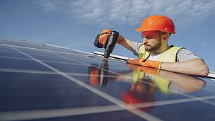 Arbeiter montiert Solaranlage