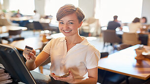 Eine Frau bezahlt an einer Kassa von einem Cafe