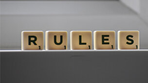 Auf Skribblebausteinen steht "Rules".