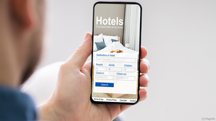Person, die ein Hotel über das Handy bucht