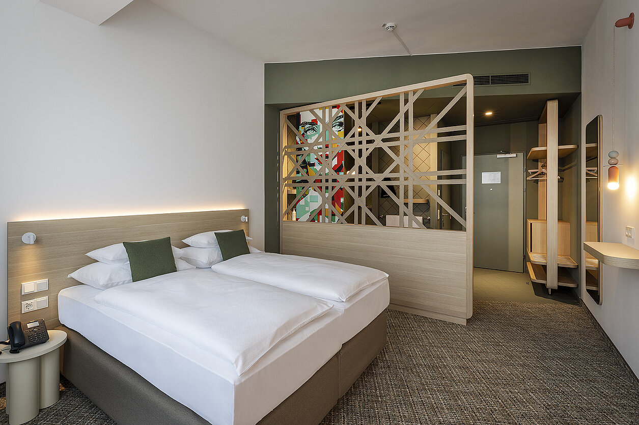 Hotelzimmer mit Doppelbett und Trennwand