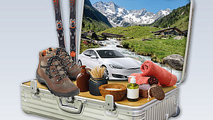 Aus einem Koffer sieht man ein Auto, Ski, Berge, ein Handtuch usw. 