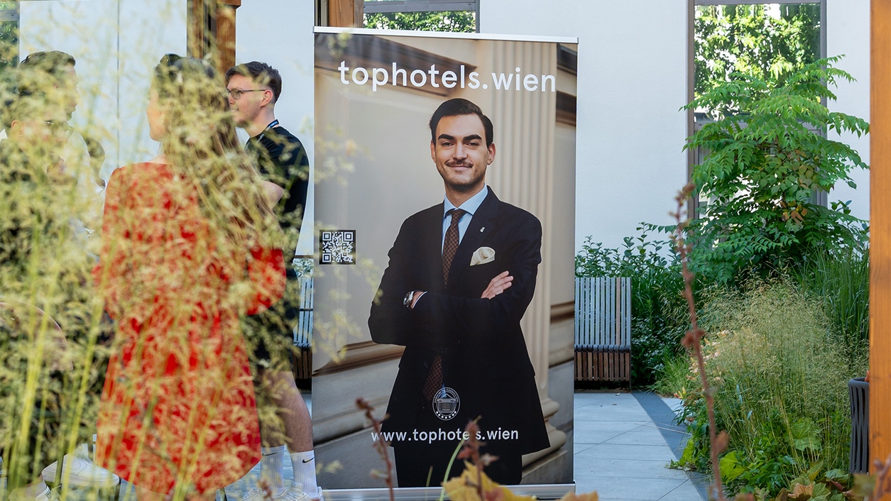 TopHotels Roll-up mit Mann im Anzug in der Hotellobby
