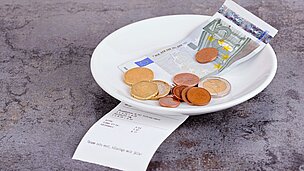 Teller mit Rechnung, Geldschein und Münzen
