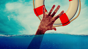 Eine Hand greift aus dem Wasser heraus und man sieht in der Luft einen Rettungsring