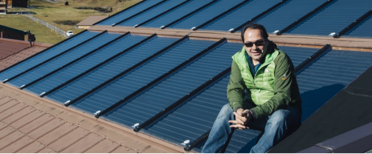 Hotelchef Oswald Jäger sitzt auf seiner Solaranlage am Hoteldach