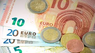 Es liegen diverse Geldscheine und Münzen auf einem Tisch