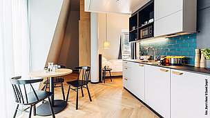 Serviced Apartment mit Küchenzeile in hell und grünen Fliesen