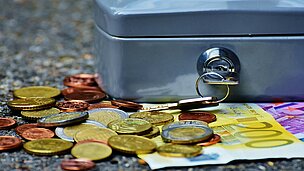 Metall-Handkassa mit Bargeld davor