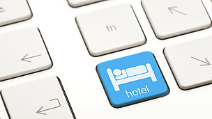 Auf einer Tastatur sieht man eine blaue Taste mit einem Bett darauf