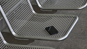 Ein Handy liegt auf einer Parkbank