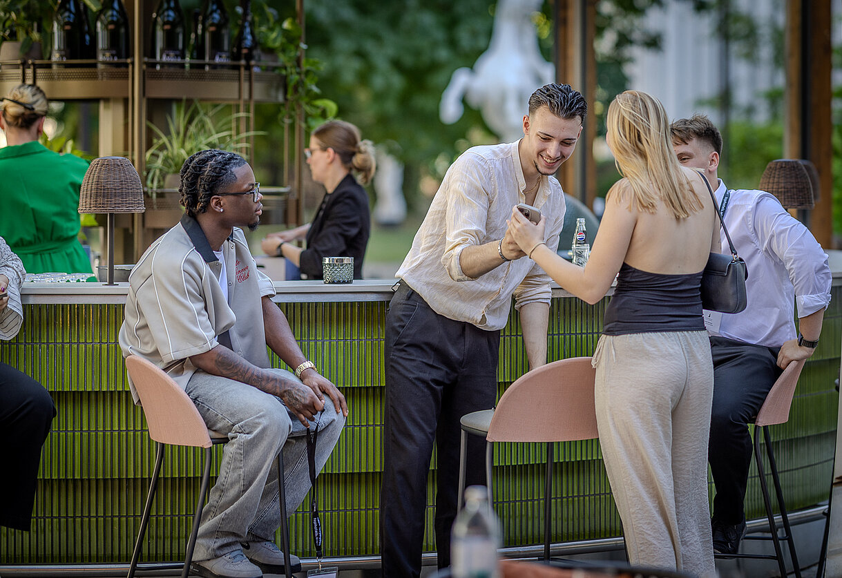 Junge Lehrlinge an der Hotelbar, zeigen ein Handy