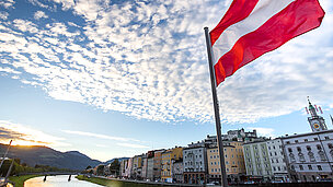 Man sieht vor Häusern eine Österreichische Flagge