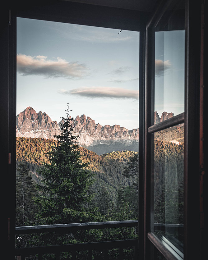 Ausblick durch ein Fenster auf die Südtiroler Bergwelt