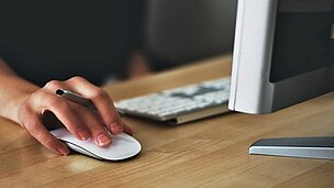Hand am Mousepad an der Rezeption