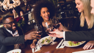 Gruppe von internationalen Gästen, die in einem Restaurant anstößt