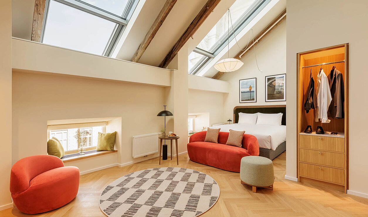 Loft mit Dachschräge rote Polstermöbel und Küche in Holz